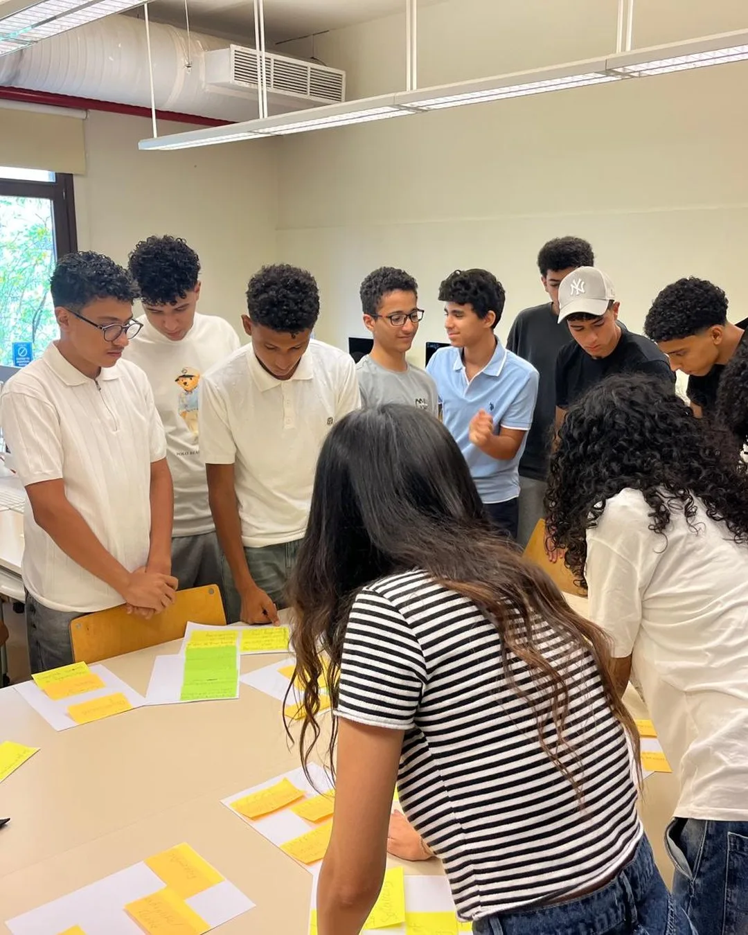 A Startopia cohort gathered around one table, mapping problems with sticky notes