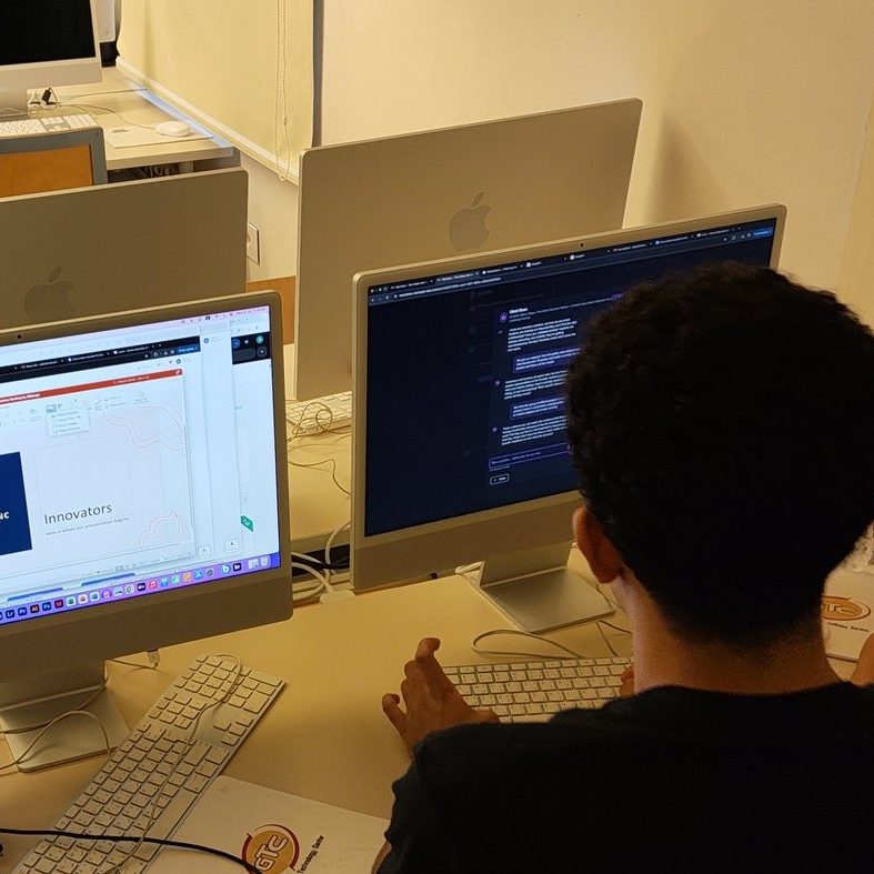 Students building their pitch decks at computers