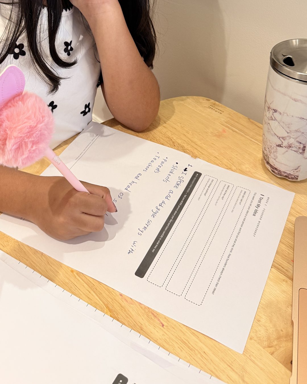 A young founder writing up her interview evidence